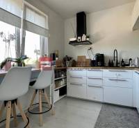 Na PREDAJ priestranný 3 izbový byt s balkónom v meste Senec - Kuchyňa v 3-izbovom byte s bielymi skrinkami a barovými stoličkami.