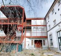 EXKLUZÍVNA INVESTÍCIA: MULTIFUNKČNÁ BUDOVA NA PREDAJ, TRNAVA - Budova na ulici Ľ. Podjavorinskej v Trnave s exteriérovým kovovým schodiskom a presklenými oknami.