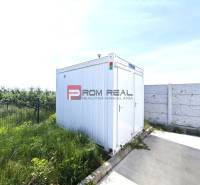 PRENÁJOM - zateplená skladová hala 547 m2, Modra - Biely kontajner vedľa plotu a betónovej plochy na Šúrskej ulici v Modre.