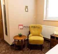 PREDAJ B&B Hotel v Starom meste - škola, centrum medicíny - Hotelová izba s kreslom, stolíkom, lampou a telefónom, vhodná pre relax.