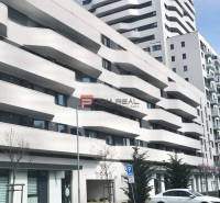 Garážové státie v bytovom komplexe Bratislava Petržalka - Budova s balkónmi na Úderníckej ulici v Bratislave V, garáže v popredí.