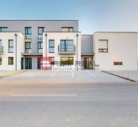5 izbový RD - 128,33 m2 v novostavbe v Alžbetinom dvore - Budova na ulici Bottova, moderná architektúra, parkovisko a rodinný dom v pozadí.