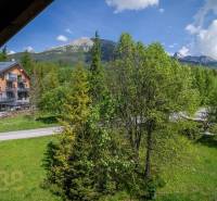 Znížená cena: priestranný apartmán s TOP polohou v Starom Smokovci - Výhľad z rekreačného apartmánu vo Vysokých Tatrách, s horami a zelenými stromami.