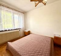 7 - IZB.ROD. DOM s GARÁŽOU, POZEMOK 2039m2, KOVÁLOV - Spálňa s posteľou, oknom a drevenou podlahou v rodinnom dome.