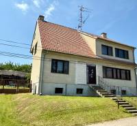 7 - IZB.ROD. DOM s GARÁŽOU, POZEMOK 2039m2, KOVÁLOV - Rodinný dom v Koválove s červeno-bielou strechou a upraveným trávnikom.