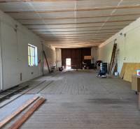 Na prenájom hala s pozemkom 4500 m² – Mníchova Lehota  - Interiér skladov a hál s drevenou podlahou, rebríky a drevené dosky na stene.