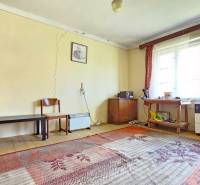 3 IZB ROD.DOM S VEĽKÝM POZEMKOM - KMEŤOVO, OKRES NOVÉ ZÁMKY - Izba s kobercami, starším nábytkom a oknami, praskliny na stenách. Pozemky - bývanie.