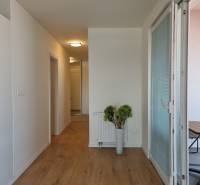 PRENÁJOM - Nový priestranný byt - Nitra, Centrum - Chodba so svetlým dreveným podlahovým povrchom v 2-izbovom byte, priestor otvorený na balkón.