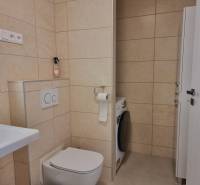 PRENÁJOM - Nový priestranný byt - Nitra, Centrum - Kúpeľňa s práčkou a toaletou v 2-izbovom byte s béžovými obkladmi.