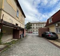 Na predaj pozemok 2269 m² so stavebným povolením na bytový dom,Trenčín - Staré budovy a zaparkované auto na M.R. Štefánika v Trenčíne, Výstavba bytov.