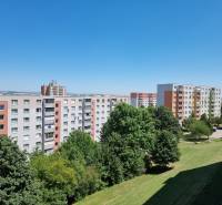 PREDAJ- Priestranný 2 izbový byt s krásnym výhľadom - Nitra, Klokočina - Sídlisko s panelákmi na Petzwalovej ulici v Nitre, obklopené zeleňou a modrou oblohou.