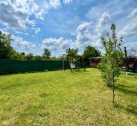 Moderný 4i rodinný bungalov 687m2 | Legionárska | Trenčín - Záhrada rodinného domu na Legionárskej ulici v Trenčíne s hojdačkou a prístreškom.