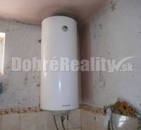 Na predaj rodinný dom v obci Rúbaň, okres Nové Zámky za výhodnú cenu! - Elektrický bojler v rodinnom dome s obkladom na stene a malým oknom.