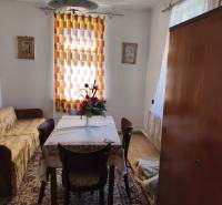 Rodinný dom Obsolovce - Jedáleň v rodinnom dome so stolom, stoličkami, kvetmi, kobercom a závesom.