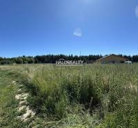 Predaj, pozemok pre rodinný dom   625 m2 Jamník - dr... - Pozemok na bývanie v Jamníku s trávnatou plochou a budovami v pozadí.