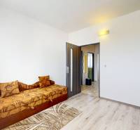 EXKLUZÍVNE: TERASA, ul. ONDAVSKÁ, 3.ízb. byt, 68m2+loggia. Kúpou voľný - Izba v 3-izbovom byte so sedačkou, drevenou podlahou a vstavanou skriňou.