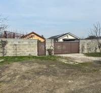 Zálesie orná pôda na predaj 3237m2 /21,- Eur / m2 - V Zálesí na ulici Domky je zobrazená uzavretá brána a betónový plot obklopujúci poľnohospodárske a lesné pozemky.