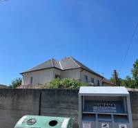 4iz RD Sasinkovo - Rodinný dom v Sasinkove na ulici Sasinkovo za betónovým plotom s modrým nebom.