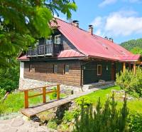 PREDAJ - Rodinný dom na Donovaloch s 3 samostatnými apartmánmi - Rodinný dom v Donovaloch s drevenou fasádou a červenou strechou v prírodnom prostredí.