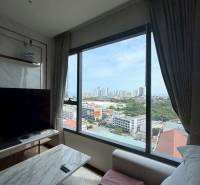 2 SPÁLŇOVÝ APARTMÁN ONCE PATTAYA - Obývačka 3-izbového bytu s výhľadom na mesto, pohodlným gaučom a TV stolíkom.
