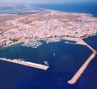 TORREVIEJA - UVÁDZACIE CENY ZA NOVOSTAVBU len 300 metrov od mora - Letecký pohľad na pobrežie mesta Torrevieja s prístavom a okolitou krajinou.