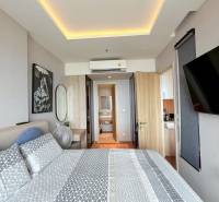 2 SPÁLŇOVÝ APARTMÁN ONCE PATTAYA - Spálňa 3-izbového bytu so vzorovanými obliečkami, zrkadlom a klimatizáciou.