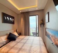 2 SPÁLŇOVÝ APARTMÁN ONCE PATTAYA - Spálňa v 3-izbovom byte s balkónom, veľkou posteľou a umeleckými obrazmi.