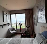 2 SPÁLŇOVÝ APARTMÁN ONCE PATTAYA - Spálňa v 3-izbovom byte so stacionárnym bicyklom a výhľadom na mesto.