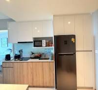 2 SPÁLŇOVÝ APARTMÁN ONCE PATTAYA - Kuchyňa v 3-izbovom byte s drevenými skrinkami a chladničkou.