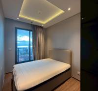 2 SPÁLŇOVÝ APARTMÁN ONCE PATTAYA - Spálňa v 3-izbovom byte s posteľou, vstavanou skriňou a závesmi pri okne.