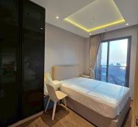 2 SPÁLŇOVÝ APARTMÁN ONCE PATTAYA - Spálňa v 3-izbovom byte s veľkým oknom a drevenou podlahou.