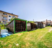 Na predaj 2-izbový byt so záhradkou a garážou! - Dvor s drevenými chatkami a bytovým domom v Púchove.