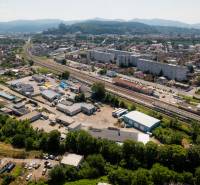 Na predaj polyfunkčný objekt na pozemku 4609 m2, TN - Zámostie - Letecký pohľad na Trenčín, Kasárenskú ulicu a Sklady a haly, v pozadí hory.