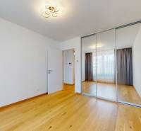 ZWIRN 2-izbový byt 54m2 + balkón 5m2 | Svätopluková - Izba v 2-izbovom byte so zrkadlovou skriňou a drevenou podlahou.