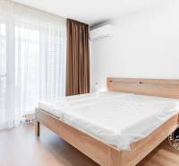 2-izbový byt, GARÁŽOVÉ STÁTIE, BA II. Ružinov, Seberíniho - Svetlá spálňa s drevenou posteľou a nočným stolíkom v 2-izbovom byte.