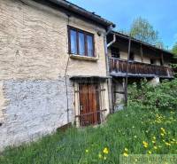 Súbor nehnuteľností určených na revitalizáciu Pohorelá -Nízke Tatry - Rodinný dom v Pohorelej, kamenné steny, drevený balkón, obklopený zeleňou a kvetmi.