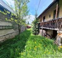Súbor nehnuteľností určených na revitalizáciu Pohorelá -Nízke Tatry - Rodinný dom v Pohorelej, trávnatý dvor s kvetmi a stromami, drevená veranda.