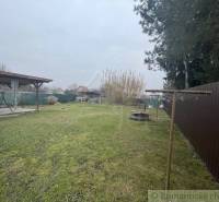 Zrekonštruovaný rodinný dom v tichej lokalite v obci Palárikovo - Záhrada s trávnikom pri rodinnom dome, altánok a sušiak na bielizeň, drevený plot.