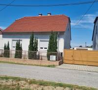 Rodinný dom na predaj - Malacky. - Rodinný dom na Riadku v Malackách s červenou strechou, predzáhradkou a drevenou bránou.