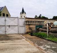 Predaj rodinného domu, Neusiedl am See - Vstupný dvor rodinného domu v 2473 Potzneusiedli s bránou a naskladaným drevom.