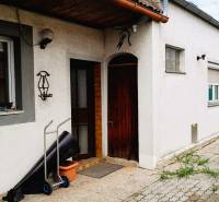 Predaj rodinného domu, Neusiedl am See - Rodinný dom v 2473 Potzneusiedl s bielou fasádou a vstupnými drevenými dverami.