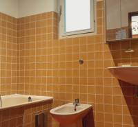 Predaj rodinného domu, Neusiedl am See - Kúpeľňa s oranžovými kachličkami v rodinnom dome, obsahuje vaňu, bidet a umývadlo.