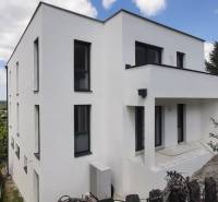 Predaj vily, Bruck an der Leitha - Vila v Hainburgu an der Donau s bielou fasádou, obklopená zeleňou a modrou oblohou.