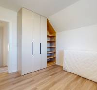 4-izbový dvojdom s terasou pre rodiny v pokojnej zóne | 97m² - Izba v rodinnom dome s drevenou podlahou, skriňou a matracom pri stene.