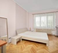 Vkusne zrekonštruovaný 3-izbový byt - Karadžičova ulica, Bratislava - Spálňa v 3-izbovom byte s posteľou, zrkadlom a drevenou podlahou.