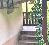 Murovaná záhradná chata, 361 m2, Zvolen - Sekier - Schodisko pri chate vo Zvolene obklopené zeleňou a dreveným zábradlím.