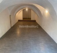 PREDAJ - investičná príležitosť - historocká budova Banská Štiavnica - - Interiér obchodných priestorov s podlahou s dreveným dekorom a klenutým stropom.
