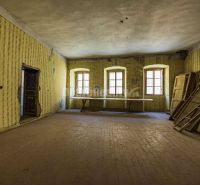 PREDAJ - investičná príležitosť - historocká budova Banská Štiavnica - - Interiér s podlahou s dreveným dekorom, oknami a starými tapetami v obchodných priestoroch.