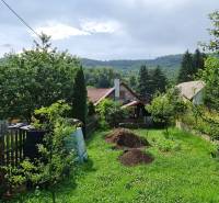 ✅ SLOVREAL Predaj rodinného domu kúsok od mesta Kremnica - Kopernica - Záber na rodinný dom s veľkou záhradou, trávnikom, a stromami v krásnom prírodnom prostredí.