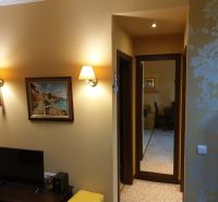 Predaj, 2 i apartmán 72 m2 + balkón výhľad na more, Burgas, BULHARSKO - Rekreačný apartmán so svetlou tapetou, obrazom a televízorom na nábytku.